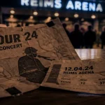 Billets concerts Reims Arena sur table, programme froissé